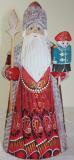 Hand carved, wooden Santa Claus in red coat with the toy soldier